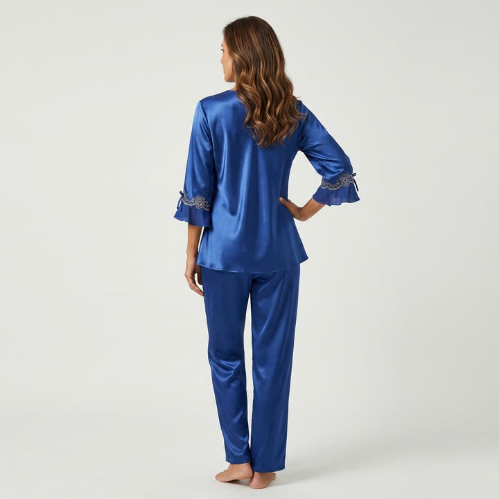 Back view of the royal blue satin-look pajama set on a model