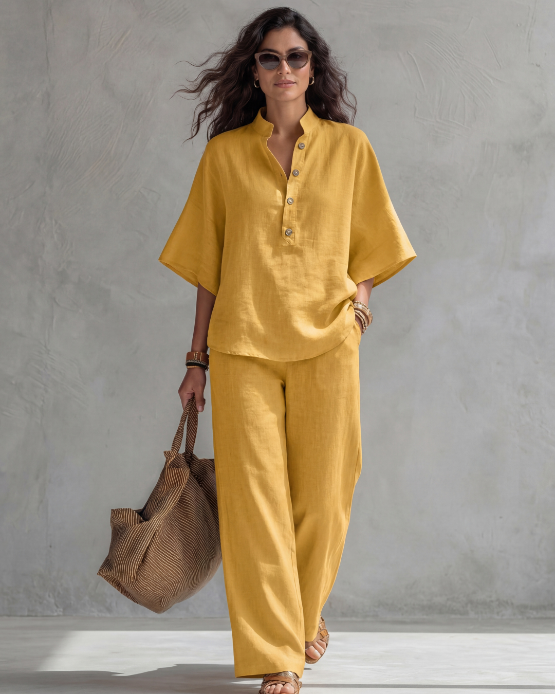 Yellow blouse and wide leg pants set worn on a concrete wall backdrop