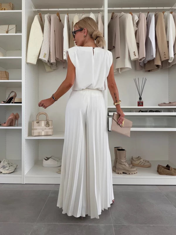 Back view of the white sleeveless top and flowing pleated wide leg pants