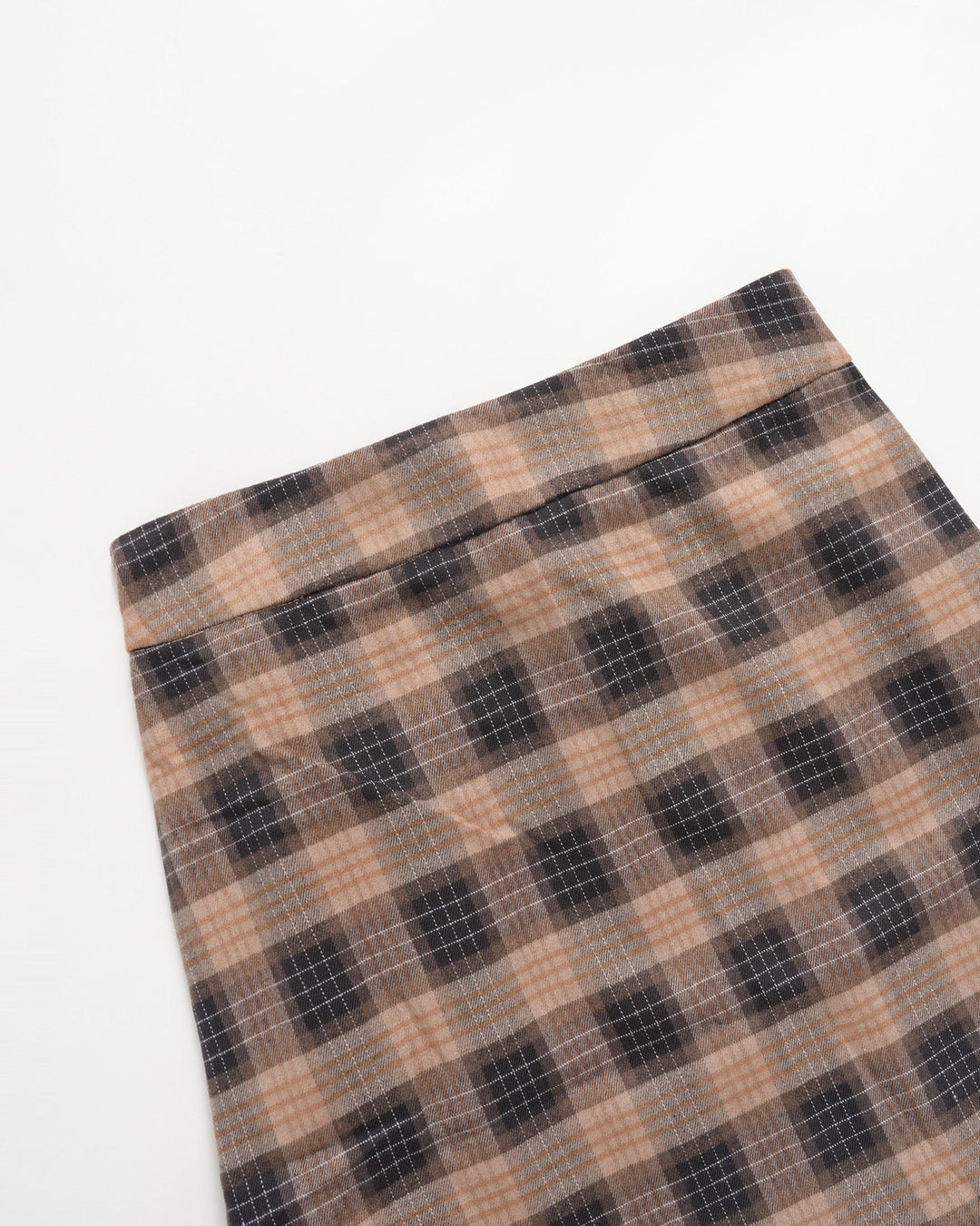 Folded corner of the brown plaid mini skirt showing the checked pattern
