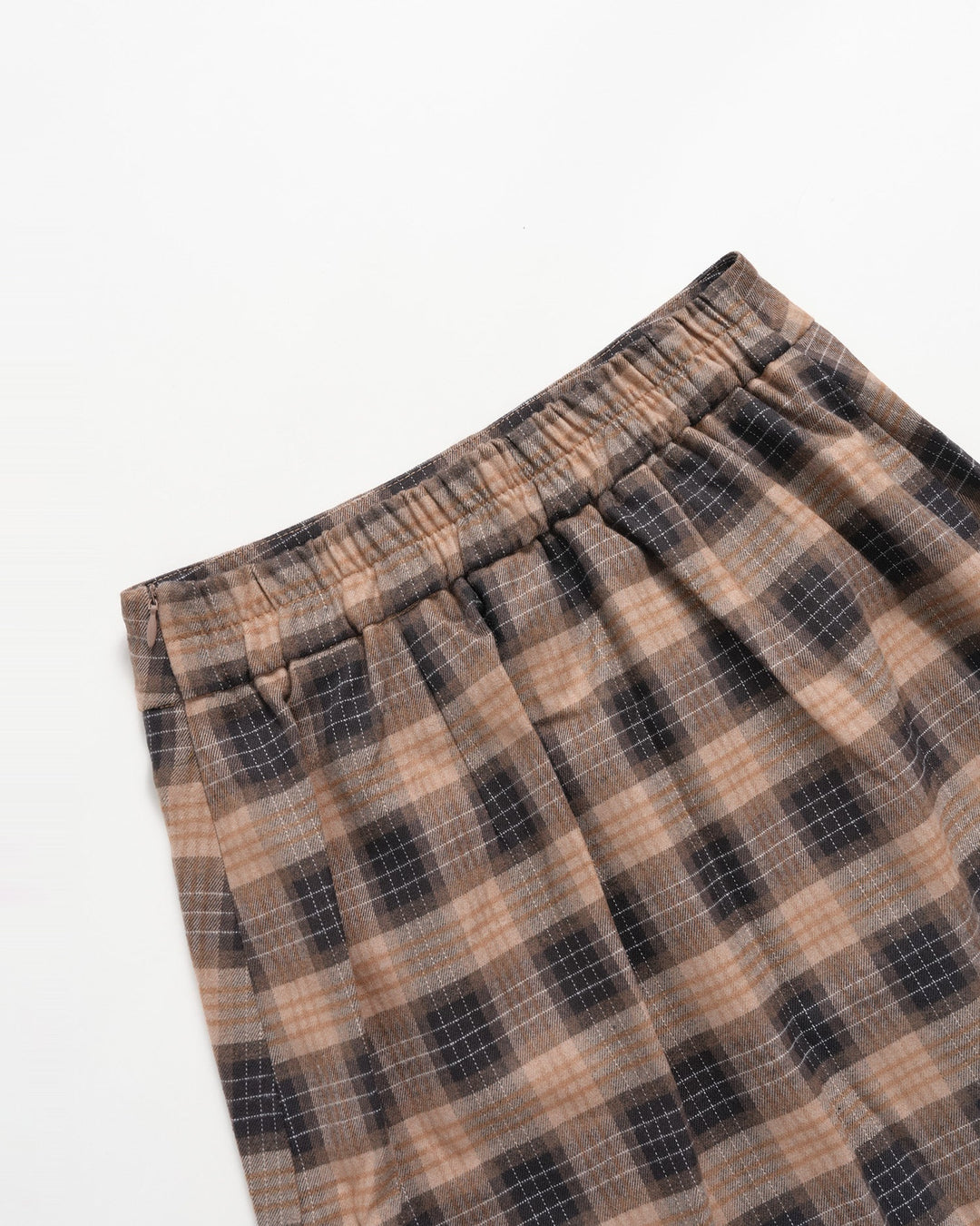 Folded brown plaid mini skirt showing the gathered elastic waist
