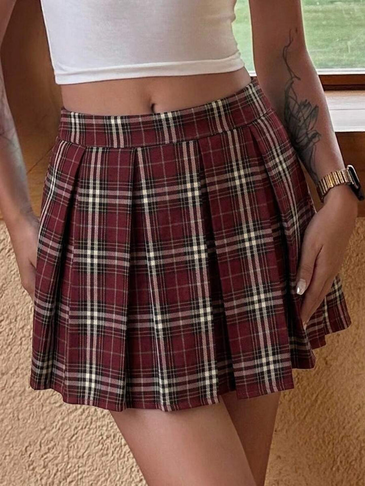 Plaid pleated mini skirt styled with a white crop top on a beige floor