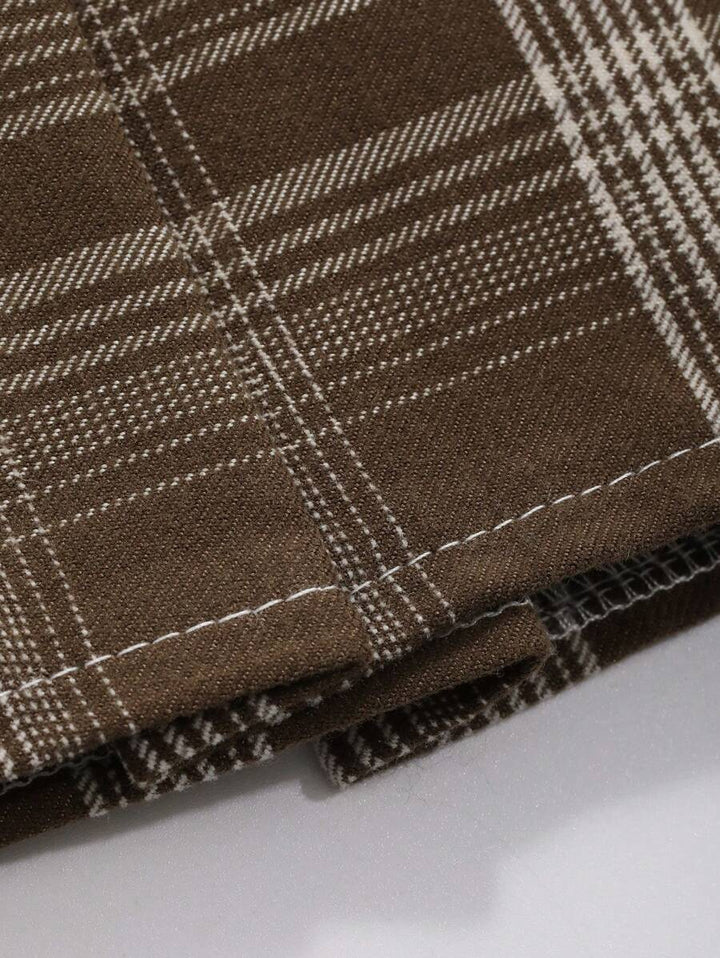 Close-up of brown plaid fabric with light checks and stitched hem