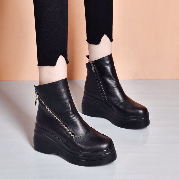 Front view of black platform ankle boots with diagonal zip and thick sole