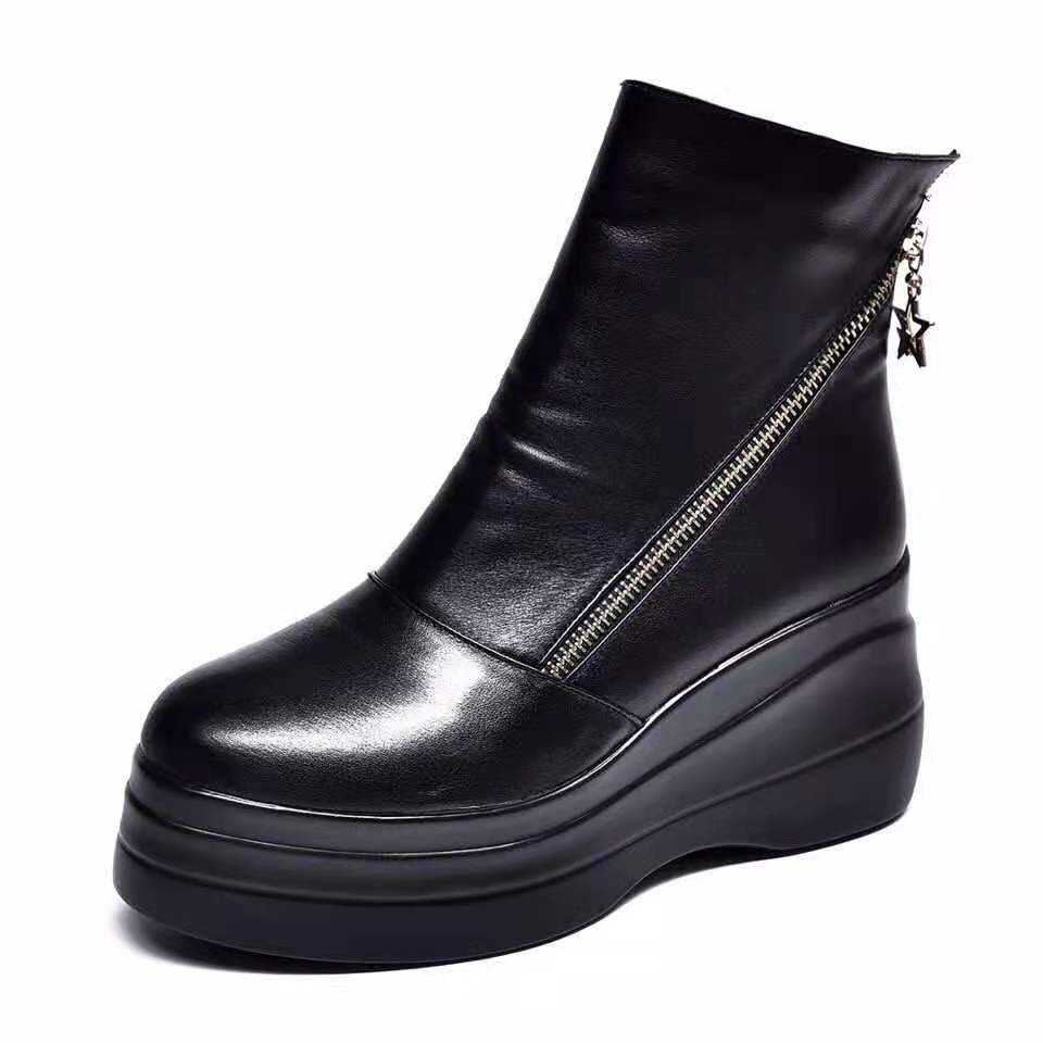Black platform wedge ankle boot with diagonal zip on a white background