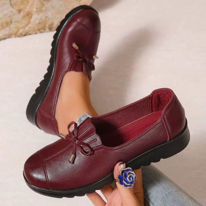 Burgundy loafers with bow and fringe, top-down view of the pair