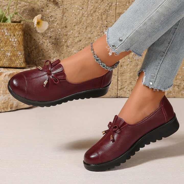Burgundy platform loafers styled with light wash jeans, side angle