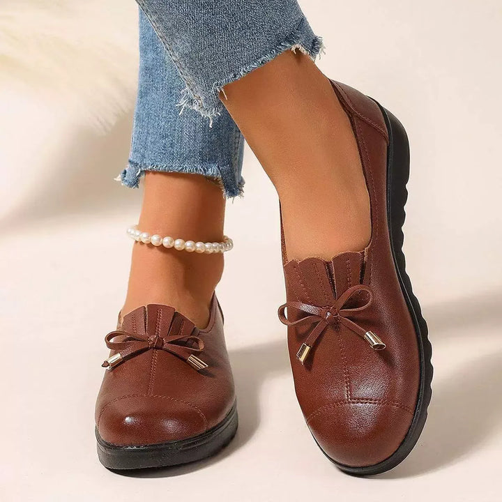 Cognac platform loafers with bow and fringe, front view on foot