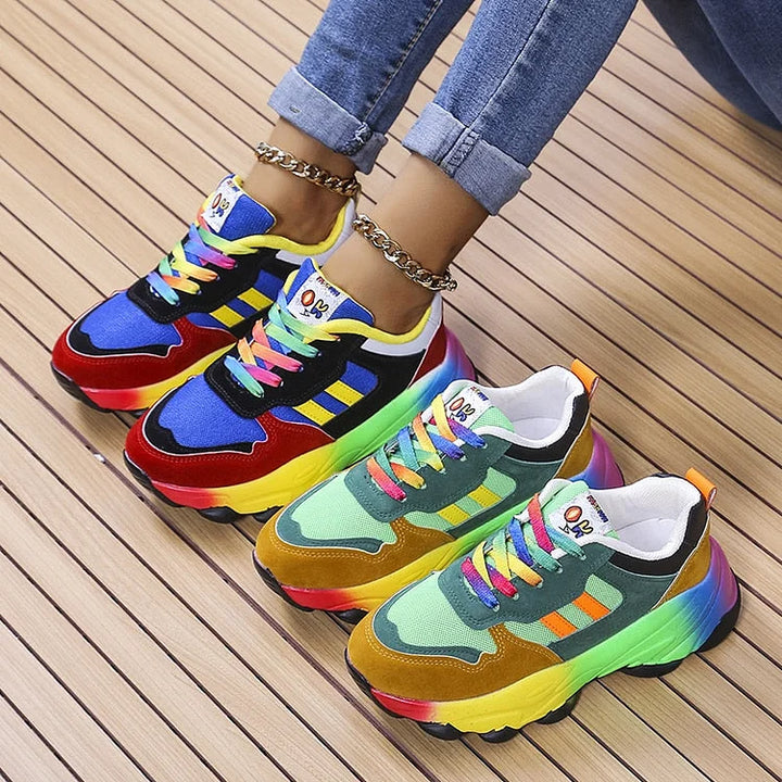 Two pairs of colorful lace up sneakers in blue and green tones on a wood floor