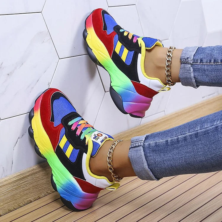 Colorful platform sneakers against a white wall with chain anklet