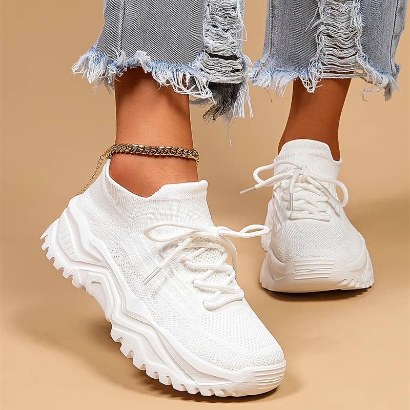 Women's white platform sneakers, worn with an anklet