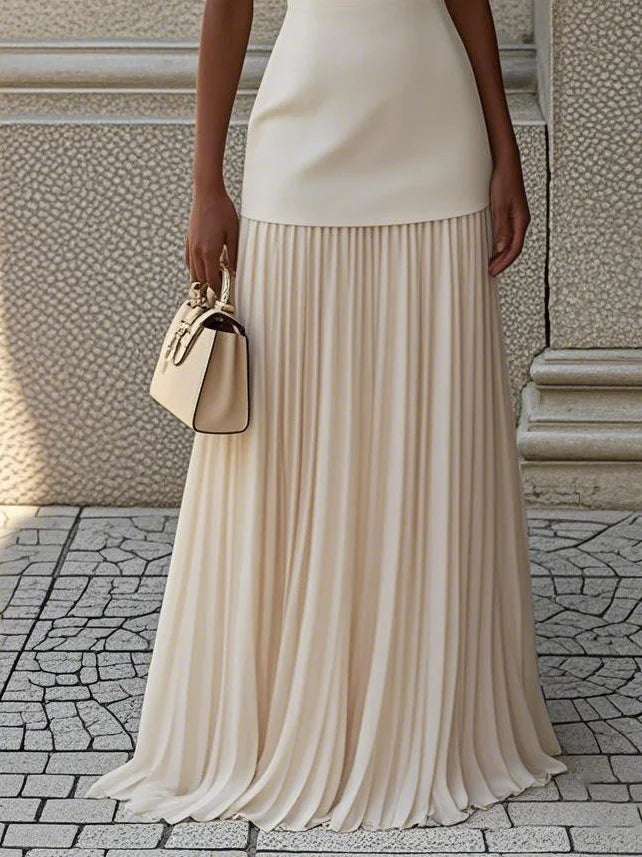 Detail of the pleated drop waist skirt in ivory with a handbag