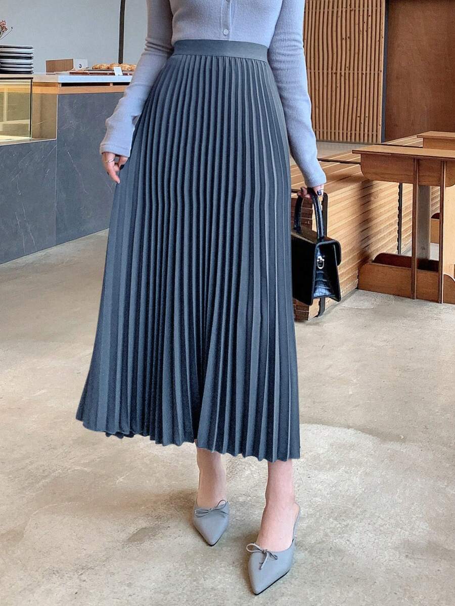 Women's pleated maxi skirt in slate blue with fine pleats, worn with a gray knit top