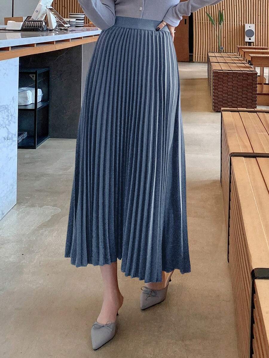 Side angle of the pleated maxi skirt showing the flowing movement of the pleats