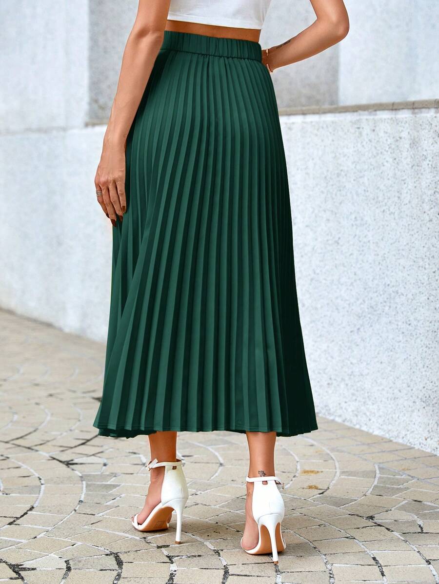 Back view of the green accordion pleated midi skirt with white heeled sandals
