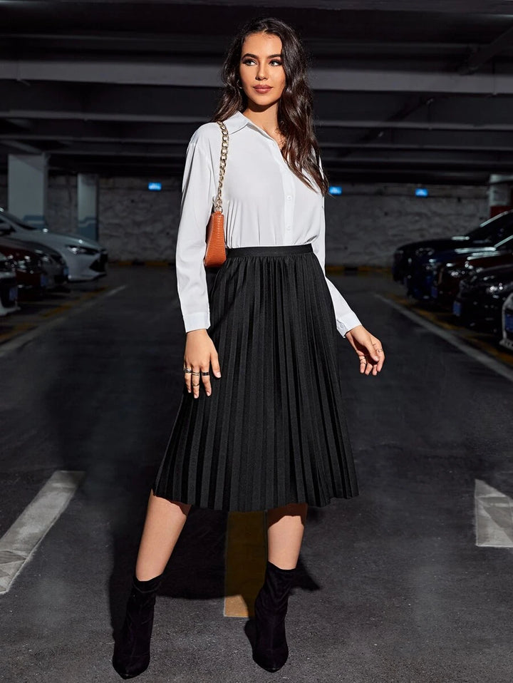 Full-length look with the black pleated midi skirt and a white blouse