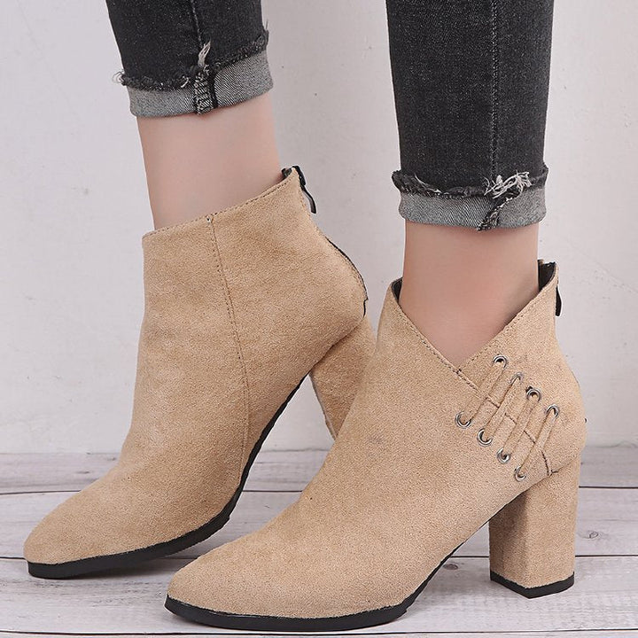 Beige ankle boots with pointed toe and side lace detail on model