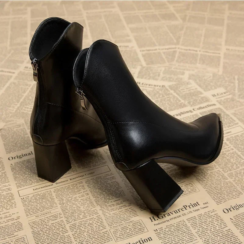 Black block heel ankle boots seen from the back with pointed toe