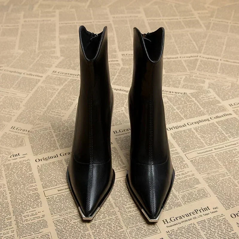 Front view of black pointed toe ankle boots with metal toe tip
