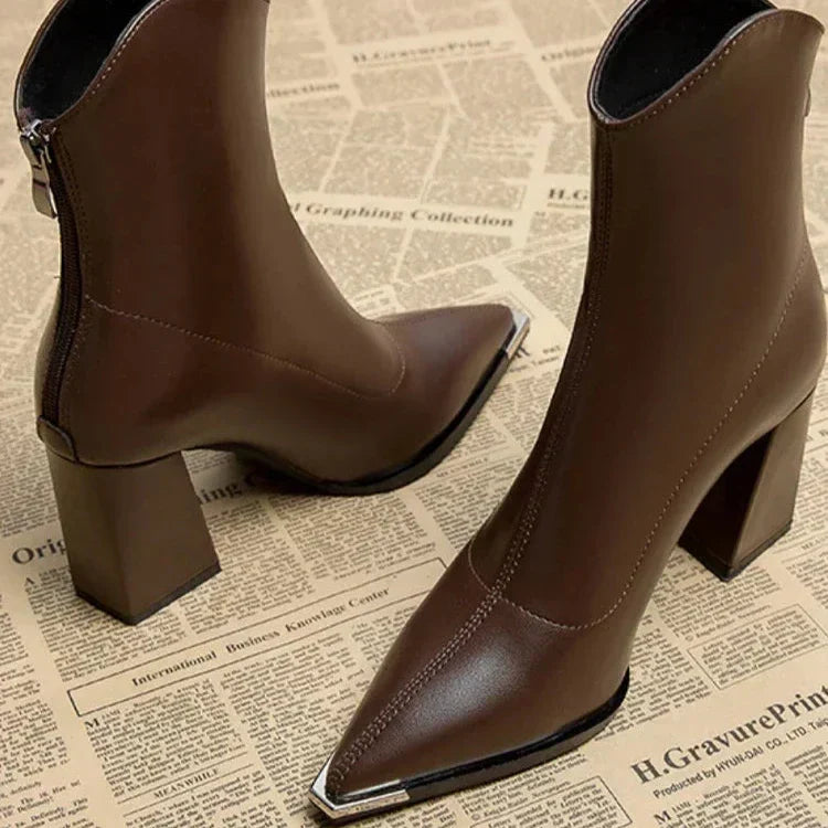 Close up of brown pointed toe ankle boots with block heel and silver tip