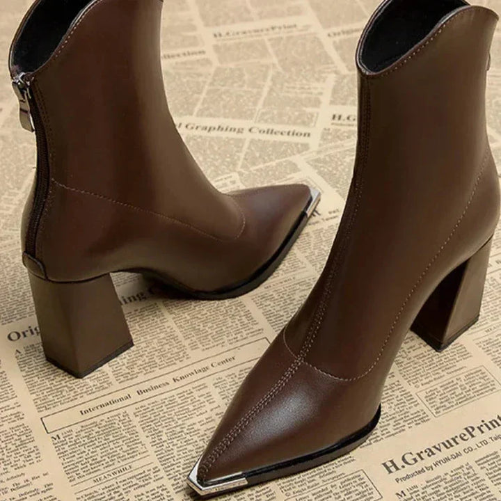 Close up of brown pointed toe ankle boots with block heel and silver tip