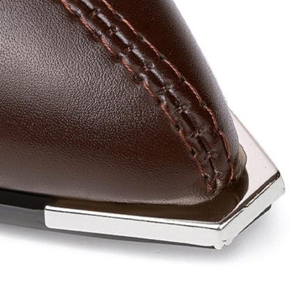 Close up of a brown boot toe with a silver metal tip and stitching