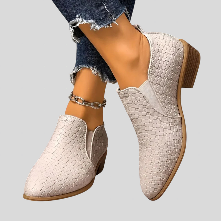 Beige woven Chelsea ankle booties with block heel, worn with cuffed jeans and an ankle chain