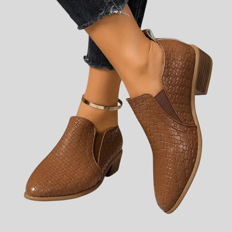 Brown woven pointed toe ankle booties with elastic side panel, worn with jeans
