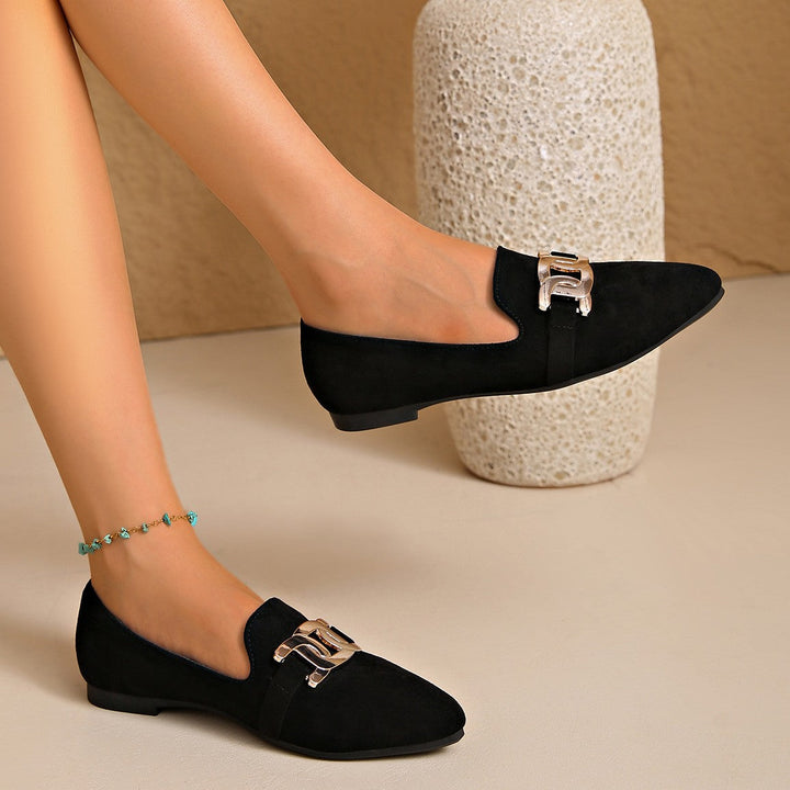 Side view of a black loafer worn with a beaded anklet