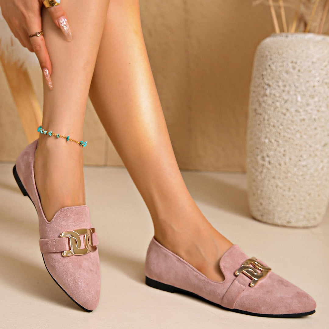 Pink suede look loafers worn standing with chain buckle visible