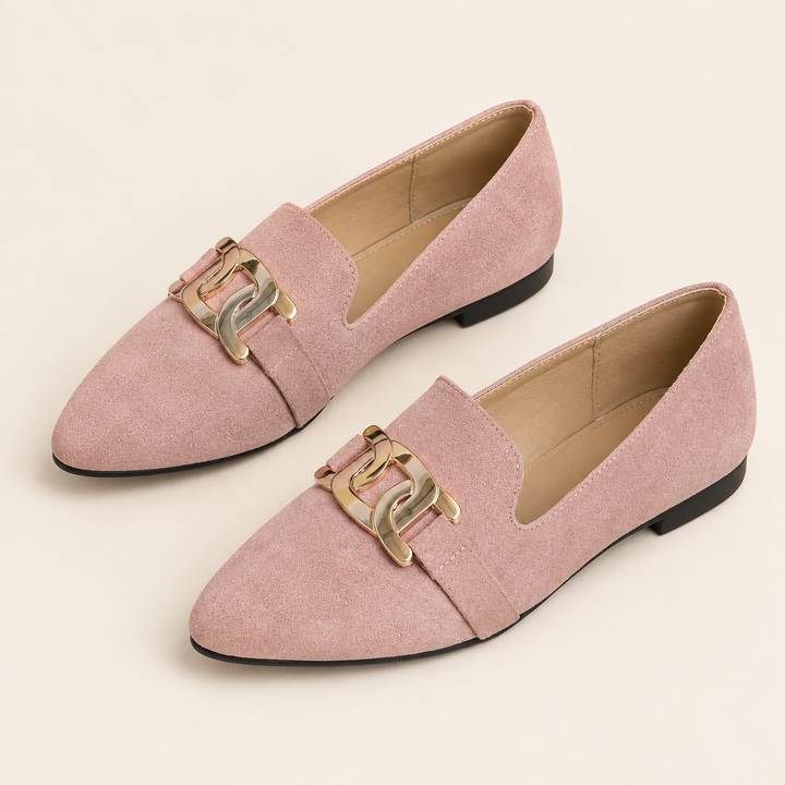 Pair of dusty pink chain detail loafers on a cream background
