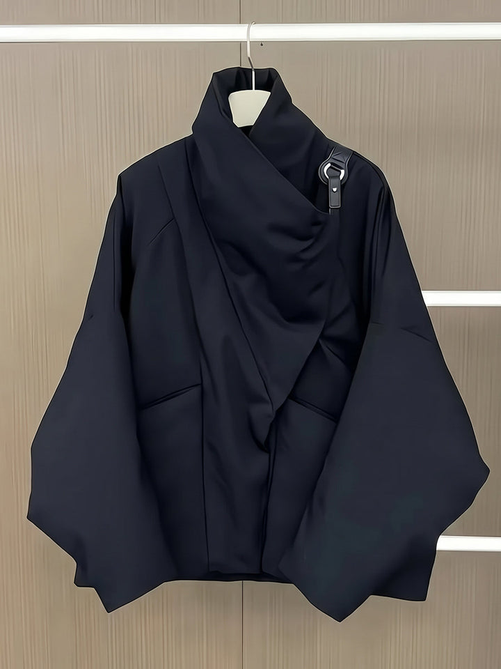 Black padded jacket on a hanger showing the folded collar and boxy shape
