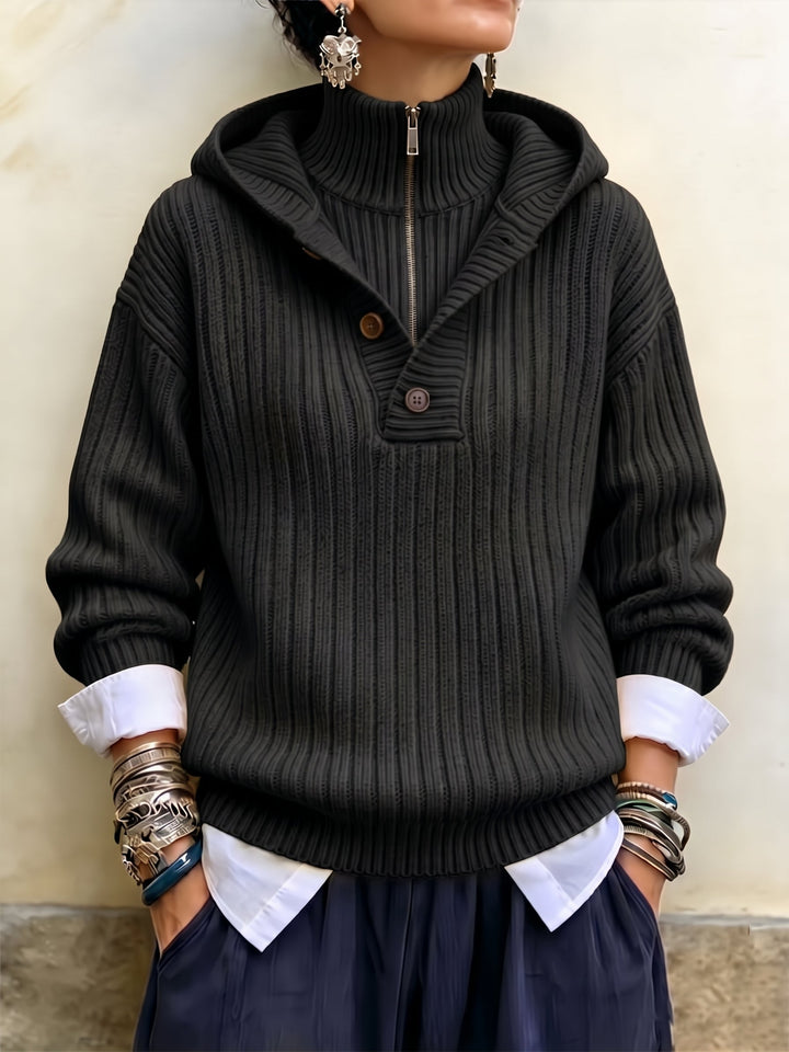 Black ribbed quarter-zip sweater with hood, styled with navy pants