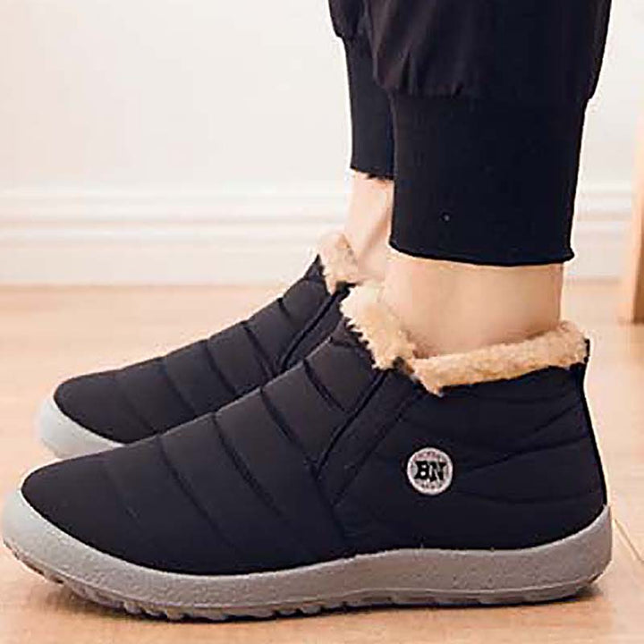 Dark quilted slip on ankle boots with faux fur lining worn indoors