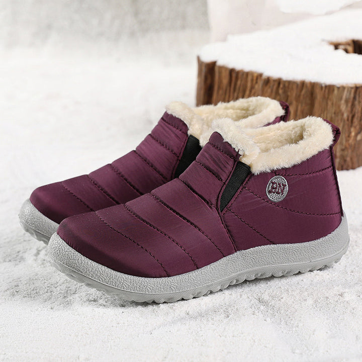Pair of plum quilted ankle boots with elastic side and fur lining