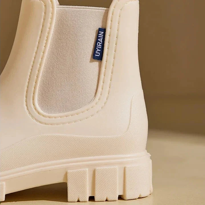 Close-up of the cream rain boot elastic panel and thick lug sole