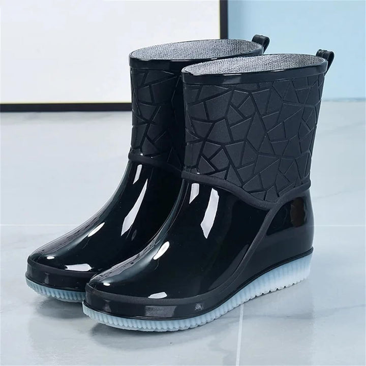 Black glossy ankle rain boots with embossed shaft and light sole