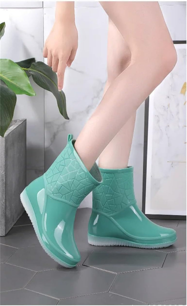 Mint rain boots worn indoors in side view, with bare legs