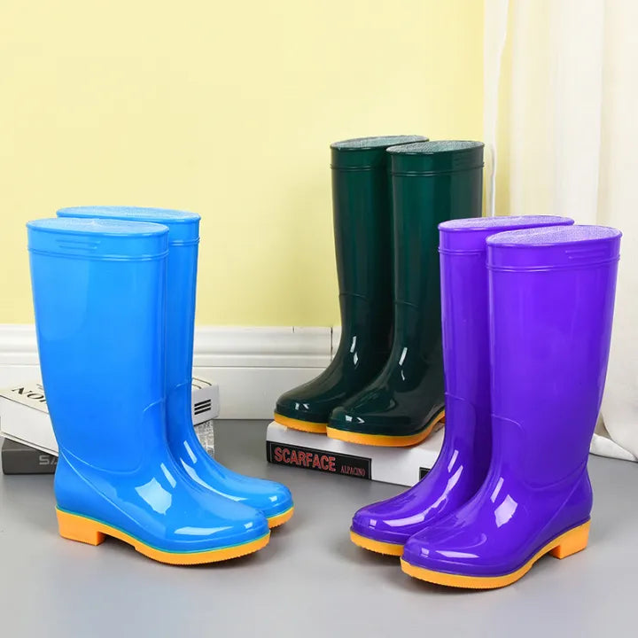 Tall rain boots in sky blue, purple and dark green lined up together