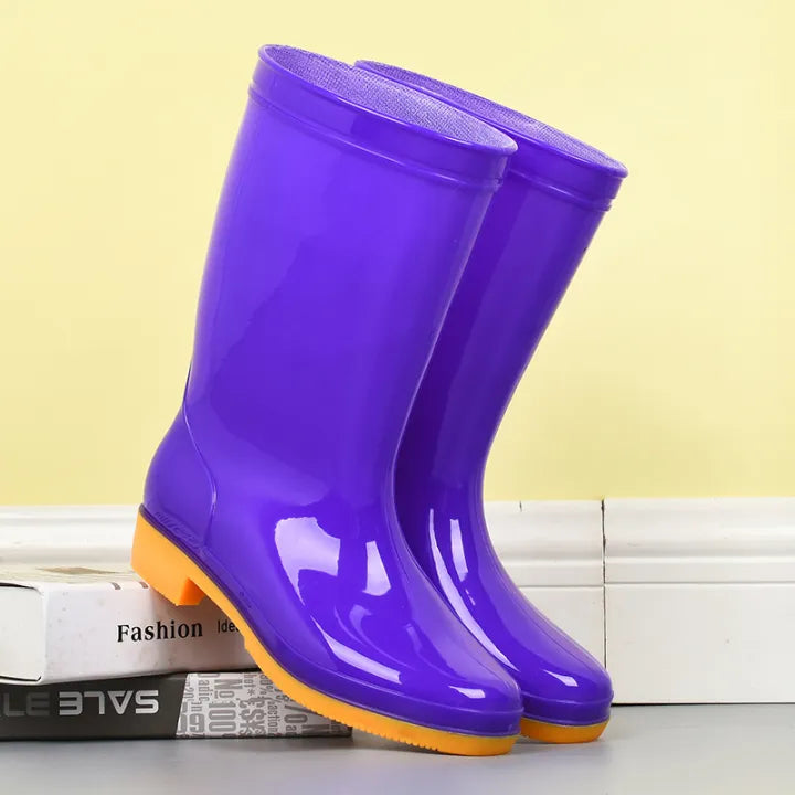 Pair of purple tall glossy rain boots with an orange contrast sole