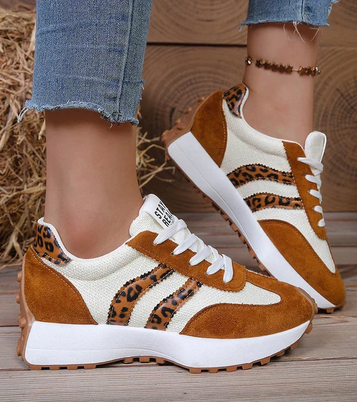 Cream and tan sneakers with leopard print stripes, worn with rolled jeans