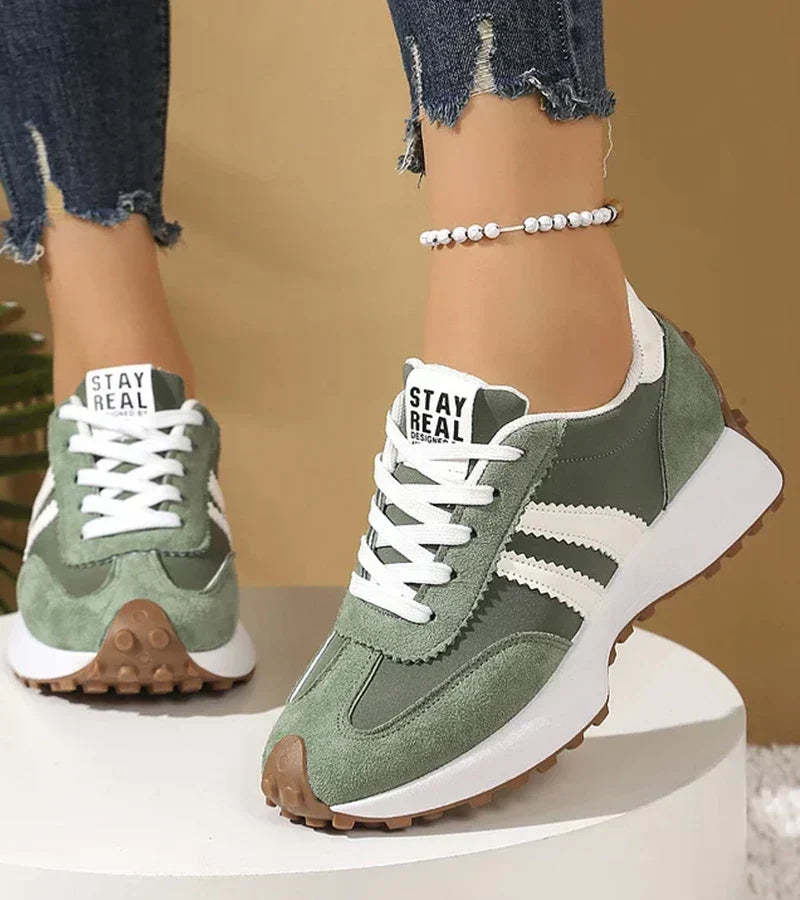 Sage green striped lace up sneakers worn with cuffed jeans and a beaded anklet