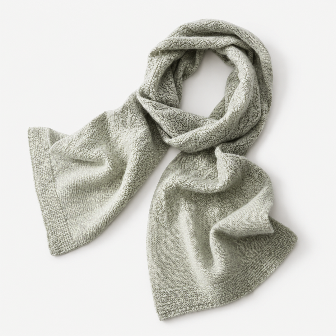 Sage green long knit scarf laid flat with textured pattern