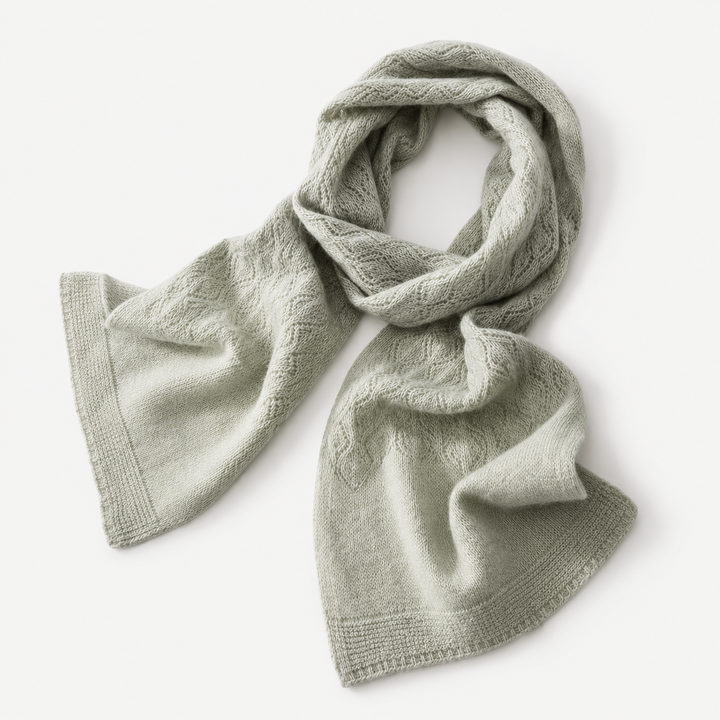 Sage green long knit scarf laid flat with textured pattern