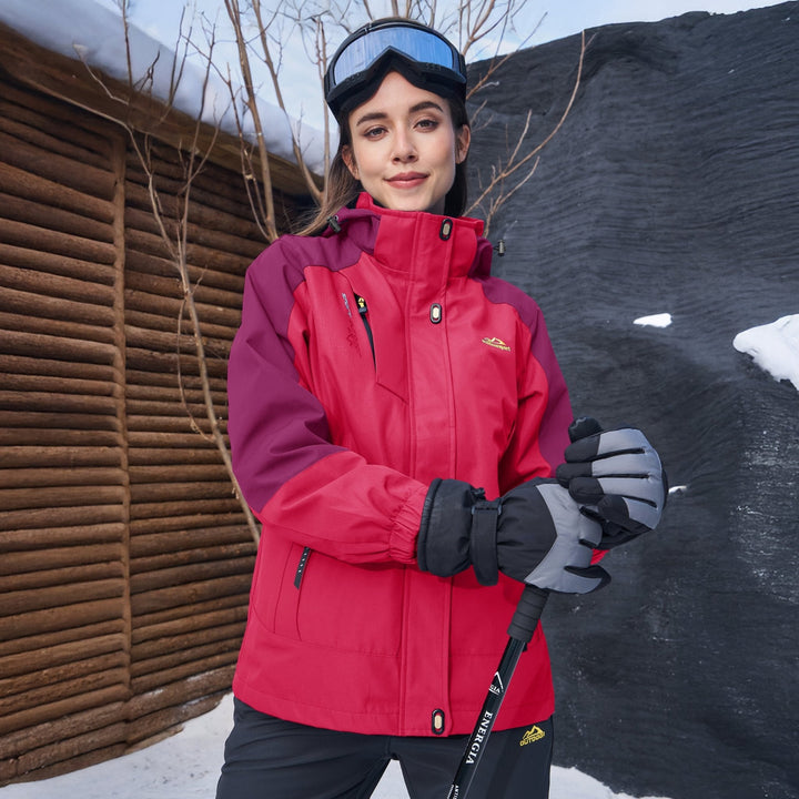 Woman wearing the rose pink snow jacket outside a cabin