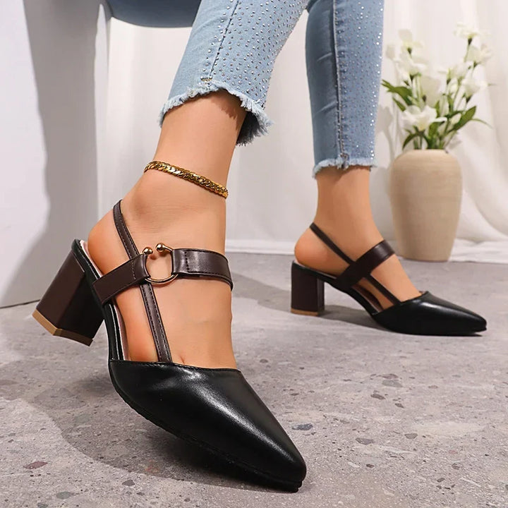 Close up of black pointed toe slingback pump with brown ring buckle strap