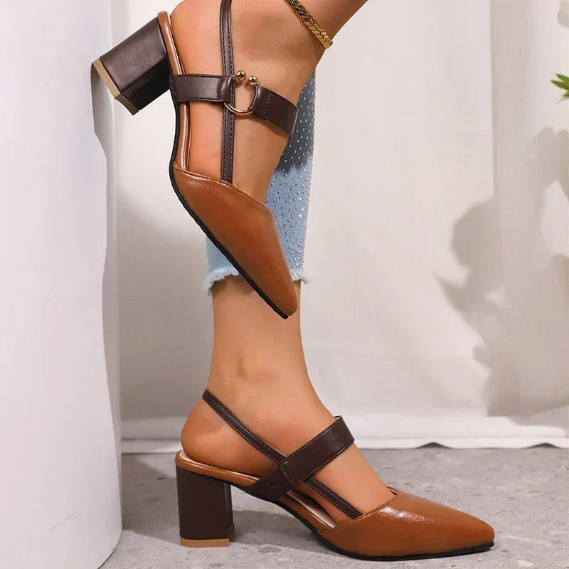 Close up of cognac slingback block heel pumps with brown strap, one shoe lifted