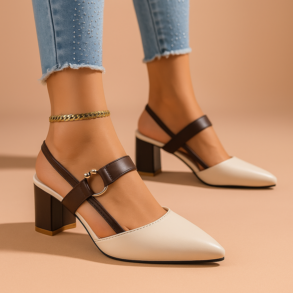 Cream block heel slingback pumps with brown straps worn with cuffed jeans on a peach backdrop