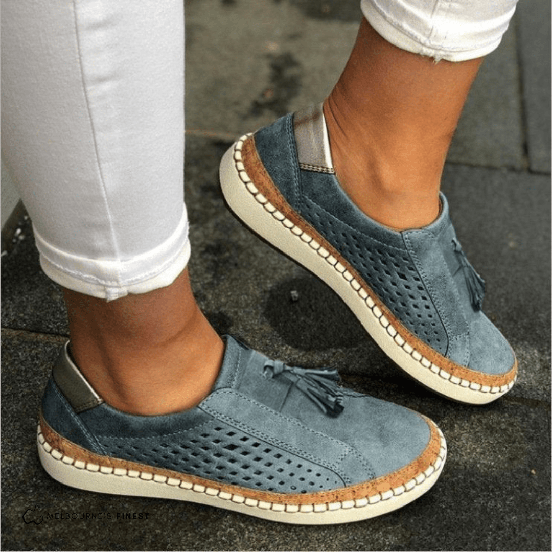 Blue perforated slip on shoes worn with white jeans