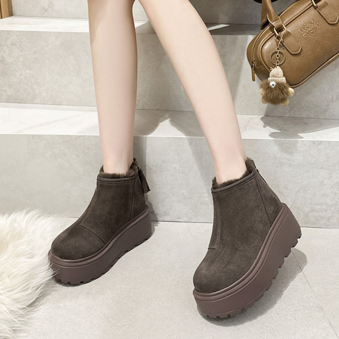 Woman wearing coffee brown platform ankle snow boots on stone steps